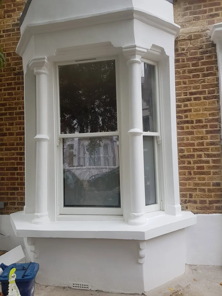 The same bay window repaired and painted white