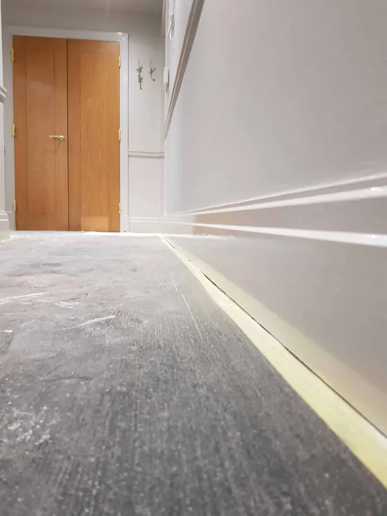 Corridor with white walls and skirting leading to oak double doors