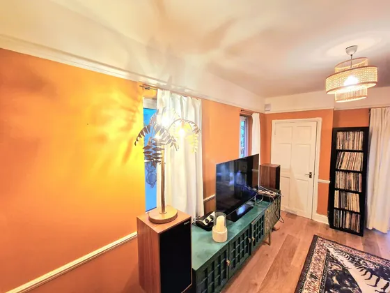 Living room painted orange with white woodwork and a white panelled door