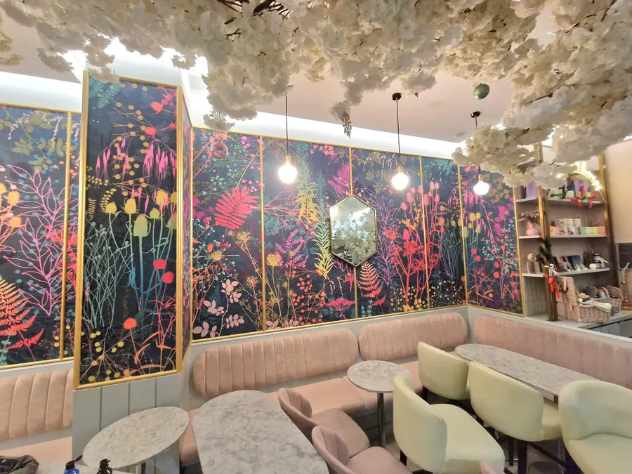 A salon with a bold floral mural wallpaper across the walls